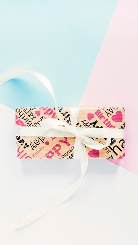 Mesa de embalagem com caixinhas, papel de seda e cartões escritos à mão, prontos para a próxima remessa que sai do ateliê da Órbita em Ipanema para todo o Brasil. Cada detalhe é cuidado para o presente chegar perfeito.